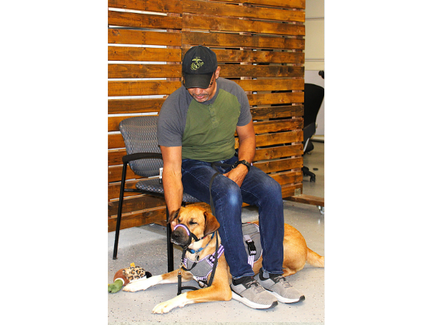 Joseph, a veteran, with his service dog Max in a public setting