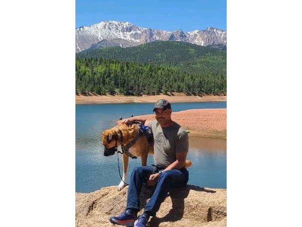 Joseph, a veteran, with his service dog Max in a public setting